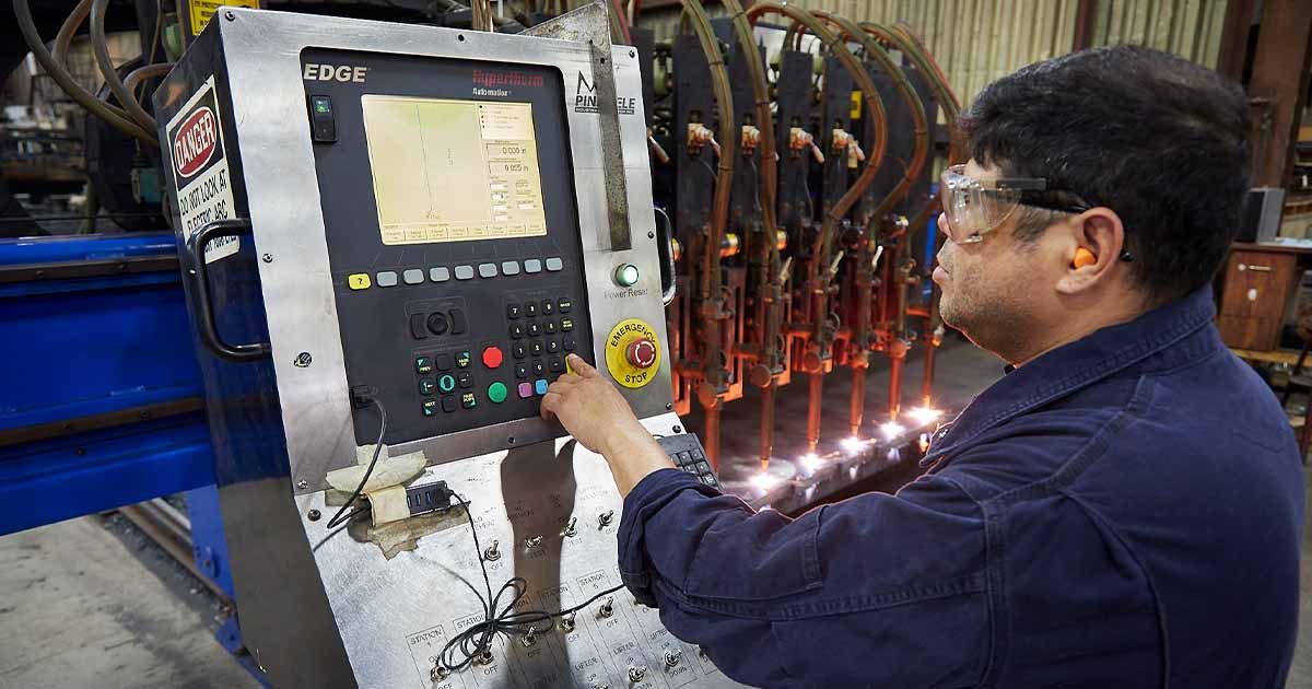 Amber Steel worker operating flame cutting machine.